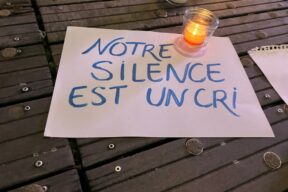 Feuille de papier posé au sol avec écrit: Notre silence est un cri.