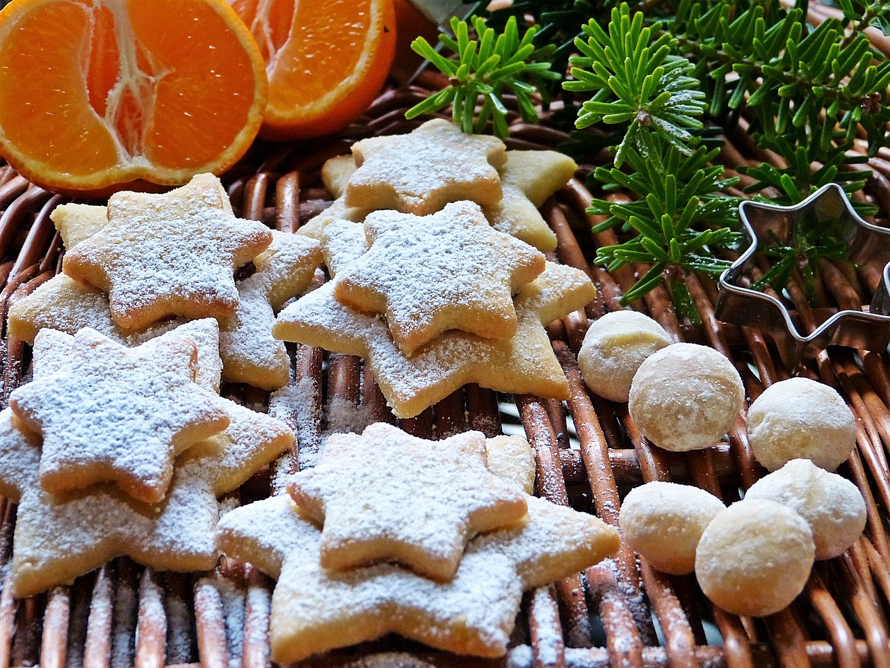 biscuits en forme d'étoile saupoudré de sucre glace, quartiers d'orange et branches de sapin