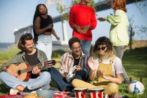 Un groupe de musiciens assis sur l'herbe.