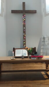 La table de communion et la croix du temple de Rennes. Sur la croix sont accrochés des post-it avec des intentions de prière.