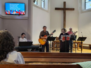 Chaplain David McLeod playing guitar and three others musicians at the temple.