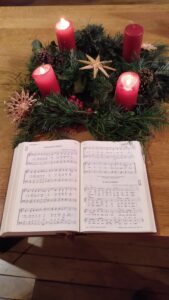 Coronne de l'Avent et recueil de cantique ouvert.
