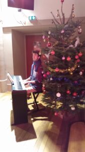 Jacques au piano devant le sapin au temple en décembre 2024