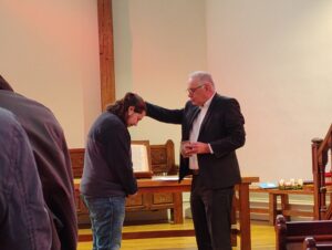 Le pasteur STÜCKER verse de l'eau sur la tête de Théo.