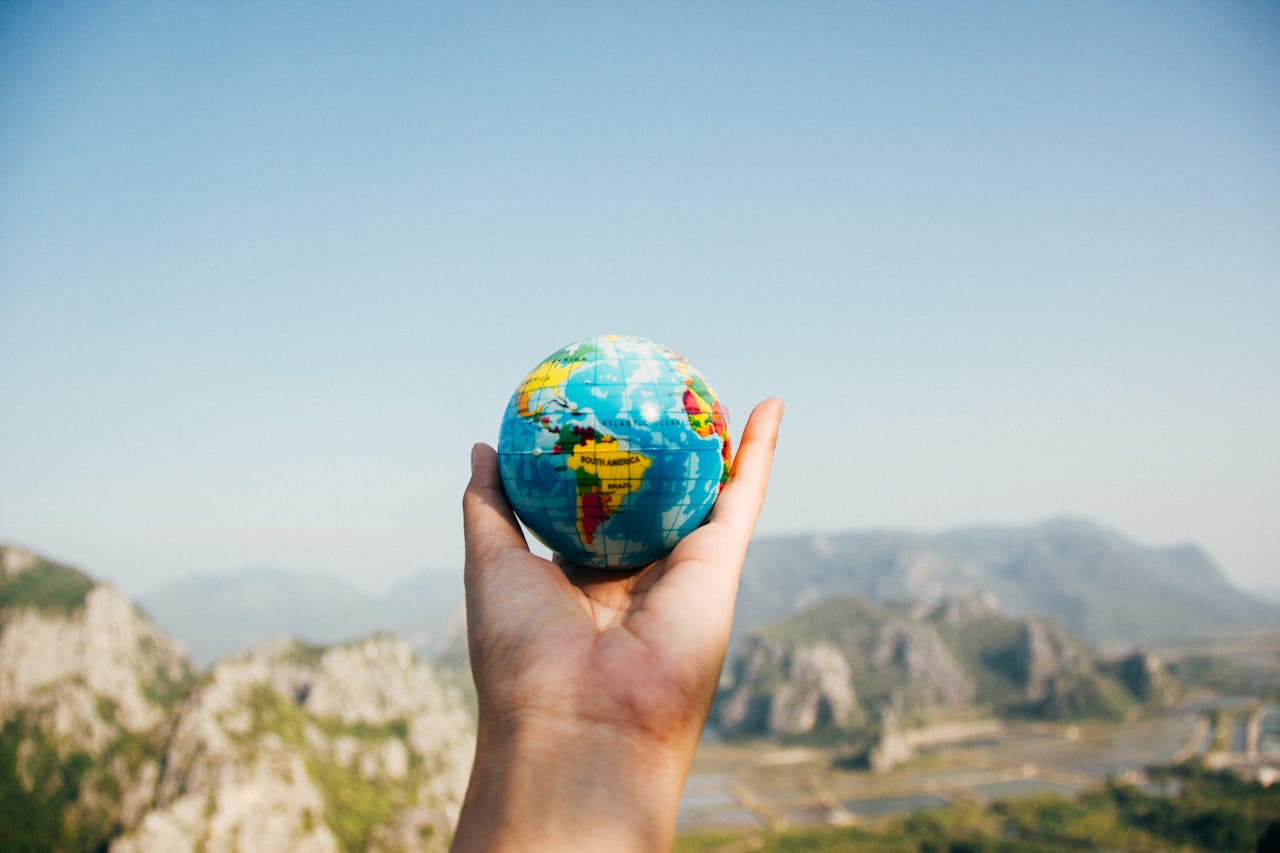 Personne Tenant Le Globe Terrestre Face à La Montagne