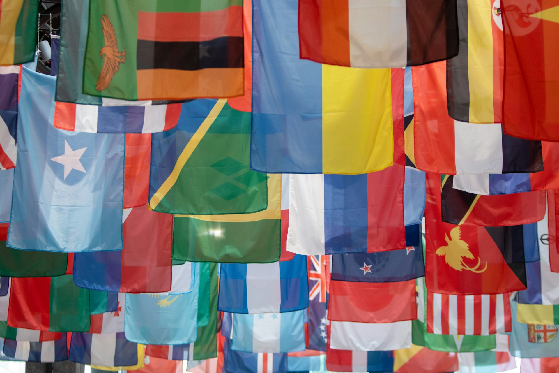 Un ensemble de drapeaux de différents pays suspsendu dans une rue.