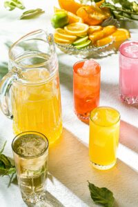 Une carafe et quatre verres de boisson fraiche.