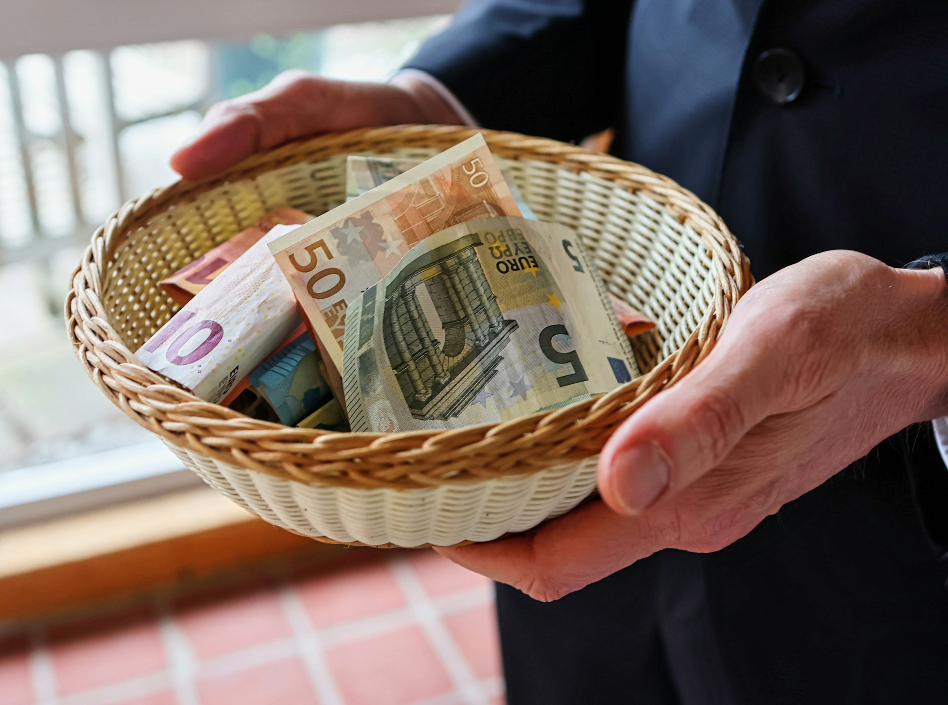 Une personne tenant un panier avec de l'argent